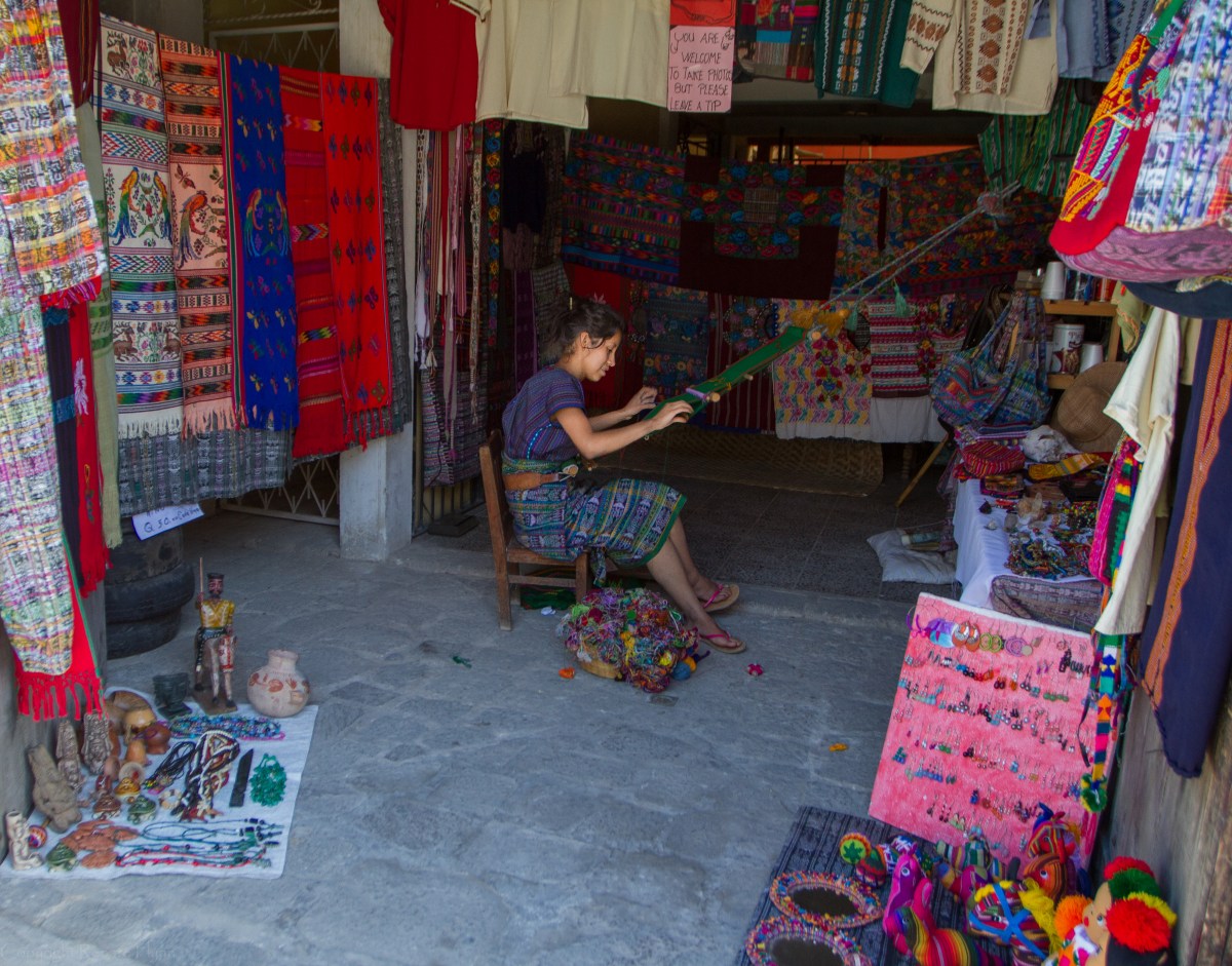 A young lady weaving the famous brightly-colored cloths of Guatemala